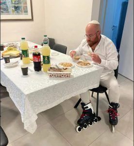 A comical picture of a religious guy breaking the fast after Yom Kippur having just rollerbladed home as quickly as possible from the synagogue.